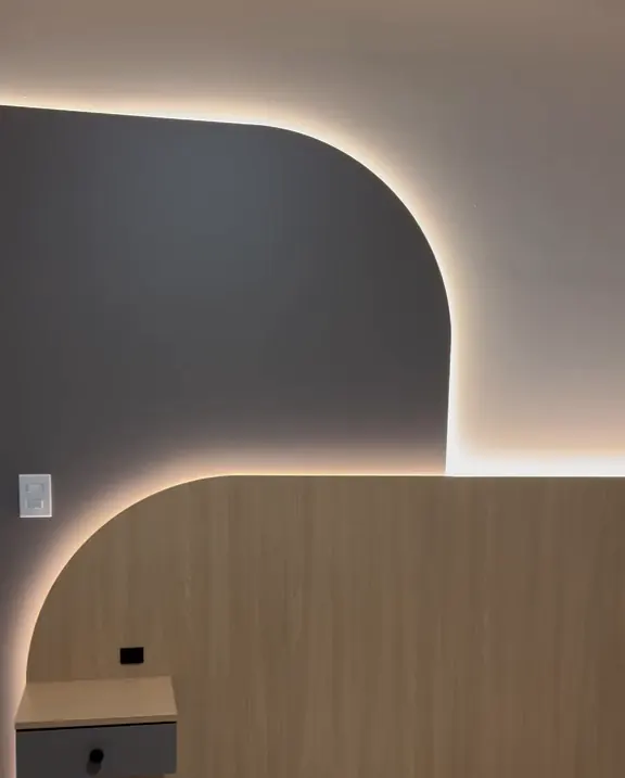 Painel de madeira com recorte curvo e luz indireta